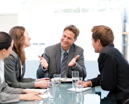 Happy team laughing together at a meeting