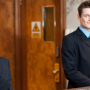 Two hotel staff members standing behind the front desk.