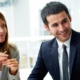 group of businesspeople sitting around a table looking at each other