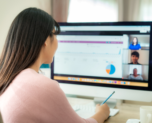 woman talking to her colleagues using cloud-based communication solutions; hybrid work communication